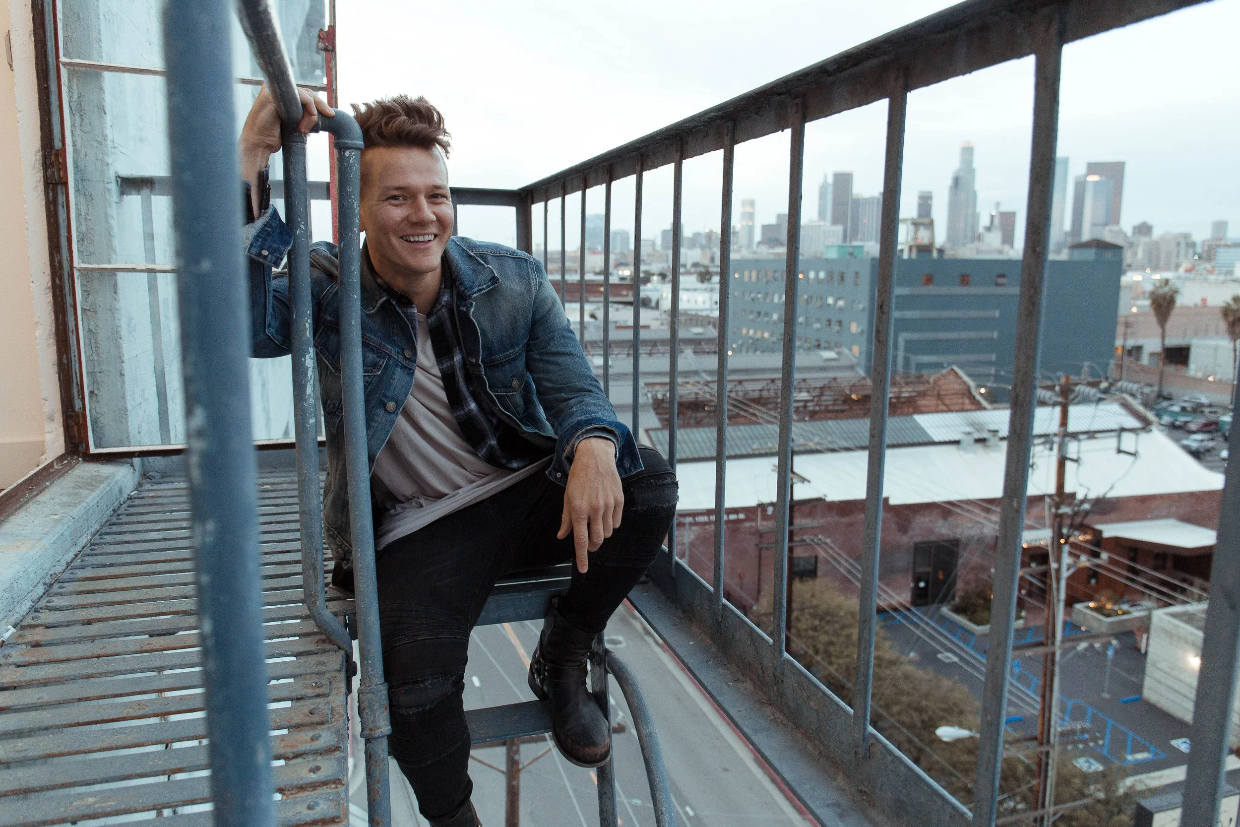 Tyler Ward seated on an outdoor fire escape